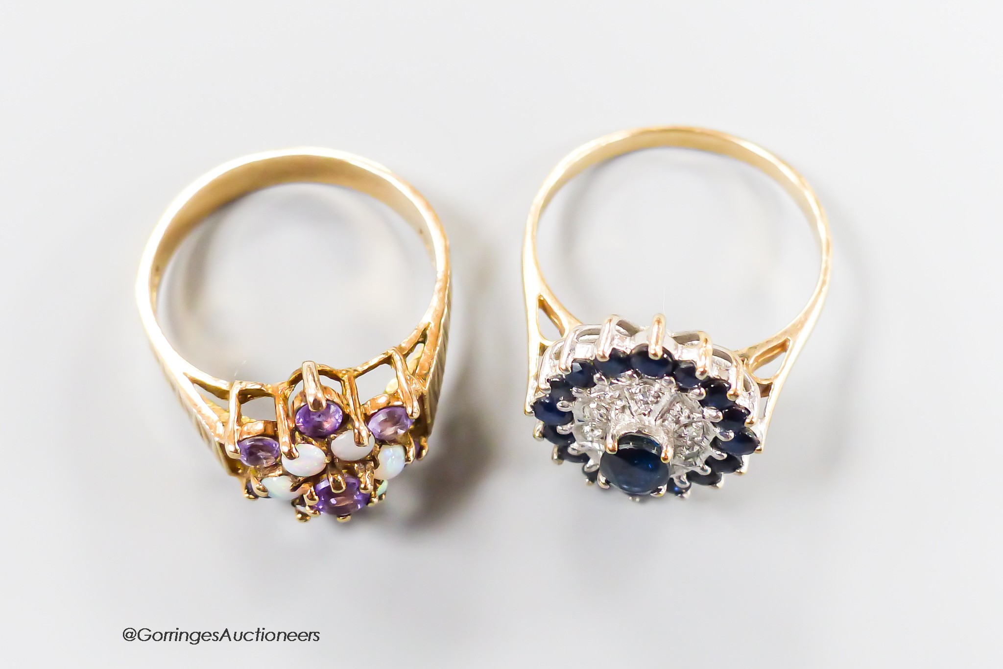 A yellow metal sapphire and diamond chip set oval cluster ring, size P/Q, gross 3.5 grams and a modern textured 9ct gold amethyst and white opal cluster set dress ring, size O/P, gross 3.7 grams.